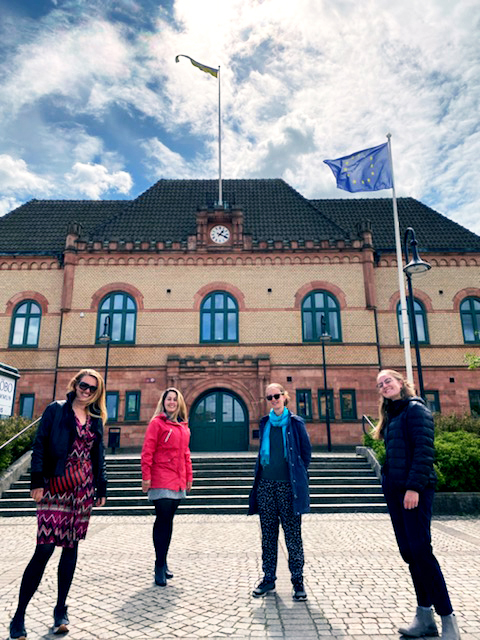 Medarbetare från Europa Direkt Sydskåne och Sjöbo och Tomelillas EU-samordnare framför Sjöbo kommunhus som flaggat för EU-dagen.